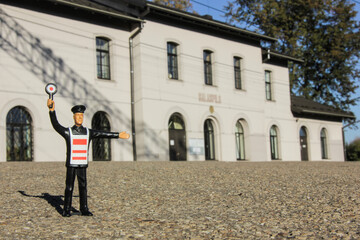 A toy railroad worker in front of railroad station