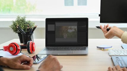 Team of creative retouchers editing digital photos, collaborating on new project together at office