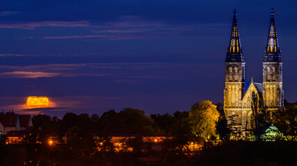 Rising full moon next to the Basilica of St. Peter and St. Paul on Vysehrad hill in Prague.