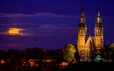 Rising full moon next to the Basilica of St. Peter and St. Paul on Vysehrad hill in Prague.
