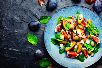 Healthy salad with fruit, olives and herbs