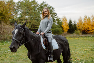 Obraz premium Woman on a horse at rancho. Horse riding, hobby time. Concept of animals and human
