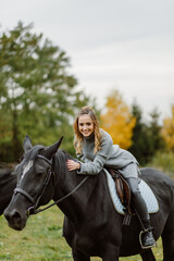 Fototapeta premium Woman on a horse at rancho. Horse riding, hobby time. Concept of animals and human