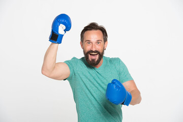 excited cheerful middle-aged bearded man celebrating success and wearing boxing gloves isolated on white background