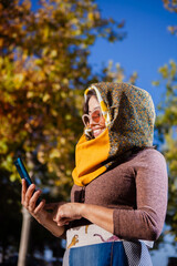 Outdoor fashion portrait of young Latin American woman, posing in a park in autumn