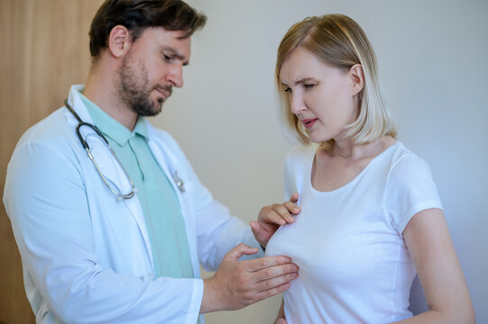 Doctor palpating the painful mammary gland of a woman