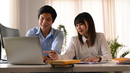 Two smiling young developer team collaborating and developing template layout for mobile application in creative workplace