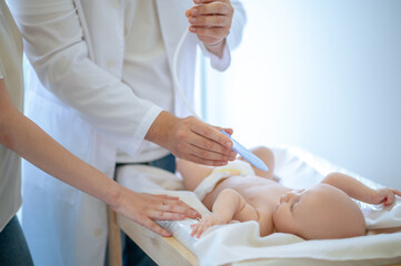 Obraz na płótnie Canvas Pediatrician examining a baby at te clinic