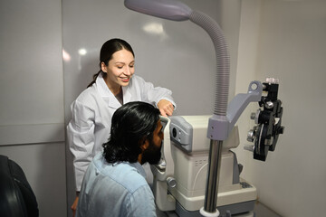 Ophthalmologist using special medical device for high precision examination eye of patient to...