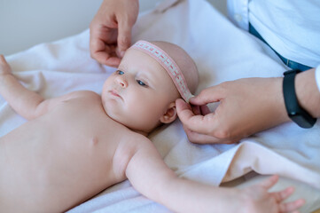 Pediatrician measuring babys body part during medical check up
