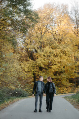 Fototapeta premium Lovely couple posing in autumn forest, lovers walking in park. lovestory in forest