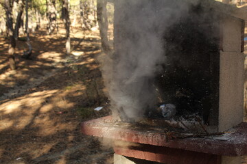 A man hand extinguished the fire in a grill with a bottle of water. Long exposure