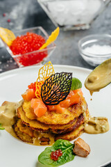 Potatoes pancakes fried with red caviar, red fish and mushroom sauce. banner, menu, recipe place for text, top view