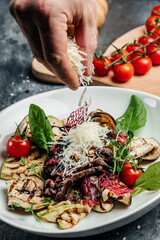 steak barbecue sliced with salad grilled vegetables, nuts, sauce and parmesan. Italian cuisine concept. vertical image. top view. place for text