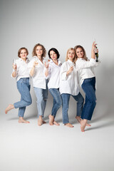 Fototapeta premium 5 girls in white shirts drinking champagne