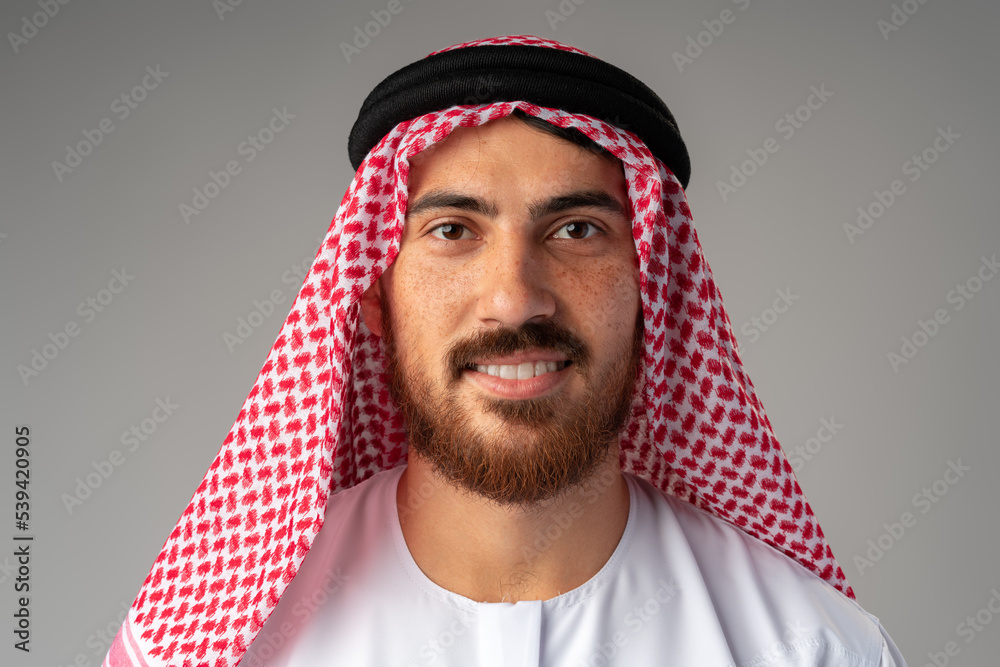 Sticker Portrait of smiling young Arab man on gray background