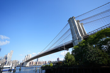Obraz premium New York City, New York USA - September 2022. Manhattan bridge. Iron bridge view. Historic New York place. Brick wall buildings. Brownstone building.