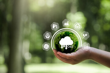 CO2 emission reduction concept in hand with environmental icons, global warming, sustainable...