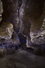 A view in a cave with gypsum crystals on the walls, which shine like small stars from the light of lanterns.
