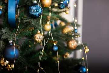 Fir tree decorated with christmas gold and blue balls. Close-up of beautiful christmas tree with...