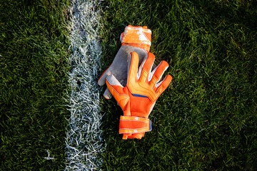 Goalkeeper gloves lay on the soccer field