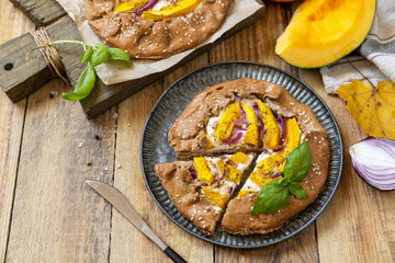 Homemade galette pie or crostata with pumpkin and ricotta cheese on rustic  background. Thanksgiving day food. Copy space.