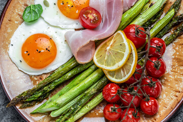 Delicious breakfast or snack. Grilled Toast witch Asparagus, fried egg, bacon jamon, ham, prosciutto on dark background. Healthy fats, clean eating for weight loss. Long banner format. top view