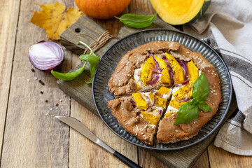 Homemade galette pie or crostata with pumpkin and ricotta cheese on rustic  background. Thanksgiving day food. Copy space.