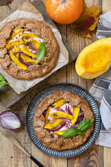 Homemade galette pie or crostata with pumpkin and ricotta cheese on rustic  background. Thanksgiving day food. View from above.