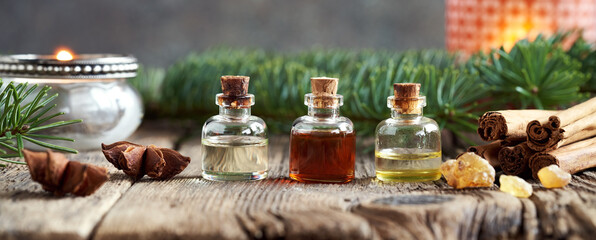 Horizontal banner with bottles of essential oil, cinnamon, fir, frankincense and star anise