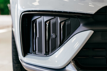 headlight and radiator grille of a beautiful matte gray car