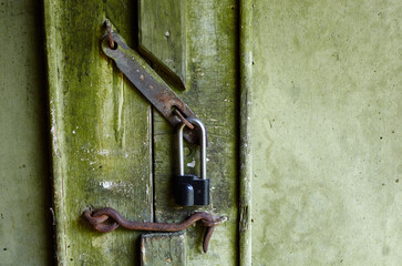 The old door to the building. Wood texture grunge background, scratched green paint on plank of wooden door
