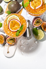 Passion fruit martini cocktail. Sweet pornstar alcoholic drink with fresh passion fruit and lime, with bar utensils copy space