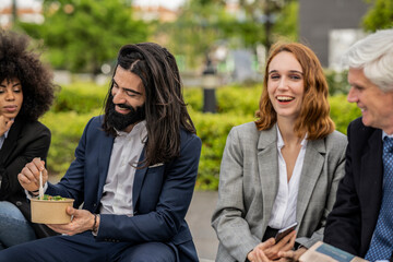 Group of businesspeople hanging outdoors during lunch break
