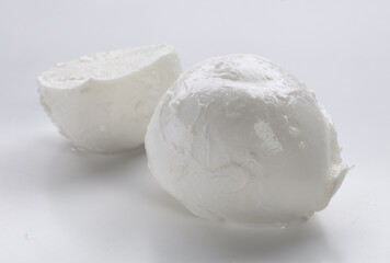 Whole mozzarella with mozzarella cut in half on a white background
