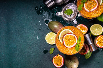 Passion fruit martini cocktail. Sweet pornstar alcoholic drink with fresh passion fruit and lime, with bar utensils copy space