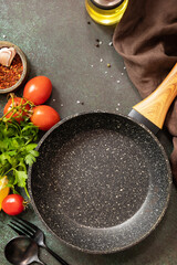 Food cooking background with Frying pan. Empty skillet, vegetables, spices and herbs on dark table background. View from above. Copy space.