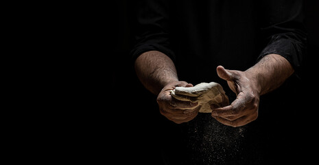 Hands of baker kneading dough isolated on black background. prepares ecologically natural pastries. place for text