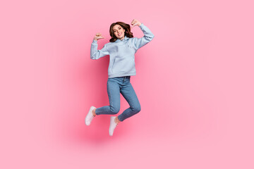 Full size portrait of crazy carefree girl jumping direct thumb fingers self herself isolated on pink color background