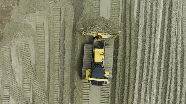 Top view of large bulldozer or crawler with GPS moving sand at construction site.