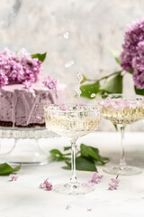 Delicious prosecco, champagne, wine with berry mousse cake bouquet of purple blooming lilacs, French cuisine, postcard, background