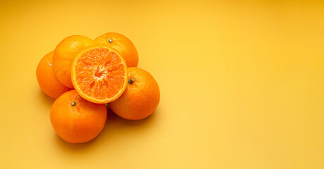 Top view of fresh oranges over a yellow background