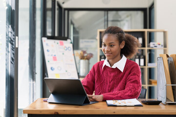 Young african american working at computer indoors at home or at office