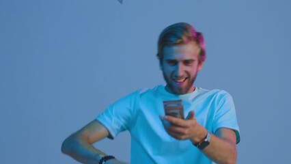 Cool young rich guy walks throwing money cash banknotes, smiling. Profitable banking offer advertisement, cash back