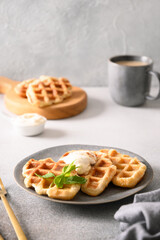 Popular fresh crispy croffles with maple syrup and coffee for delicious breakfast. Croissant as waffle. Vertical format.