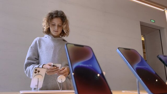 Teen chooses a new phone. Full line of new Apple phone iPhone 14 pro in Apple Store. Latest iPhones with new CPU GPU and features