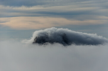 tip of the island of Es Vedra in Ibiza rising out of the mist in winter