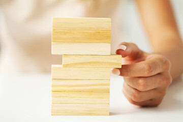 Close up woman's hand stacked wooden blocks with space for text