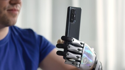 Close up of Happy young man with modern bionic arm use mobile phone reading news 