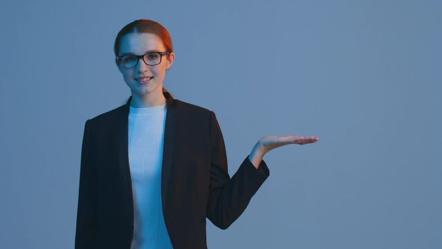 Product or service presentation. Female business person in glasses showing by palm hand mockup empty space on the go
